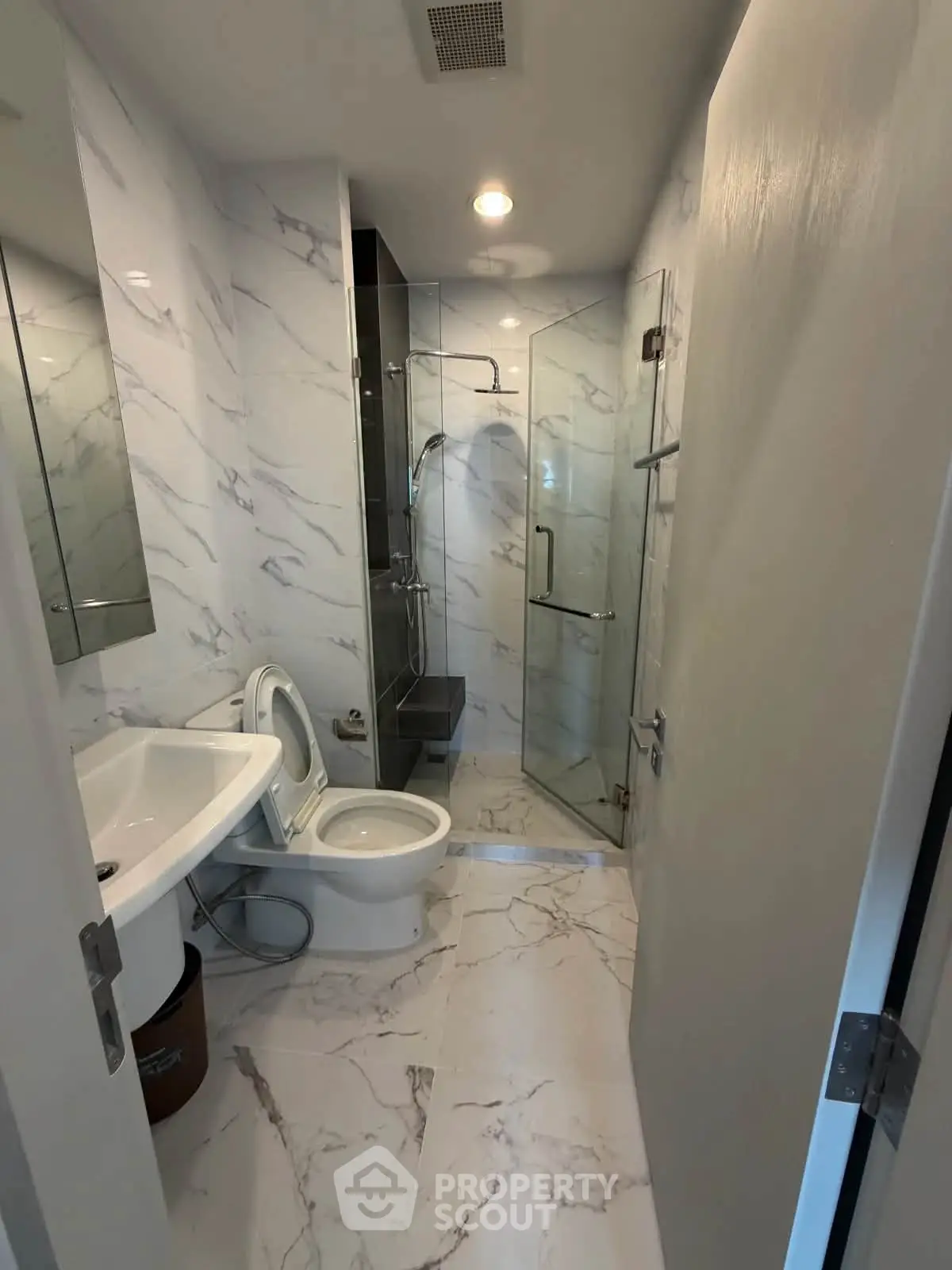 Modern bathroom with marble tiles and glass shower enclosure