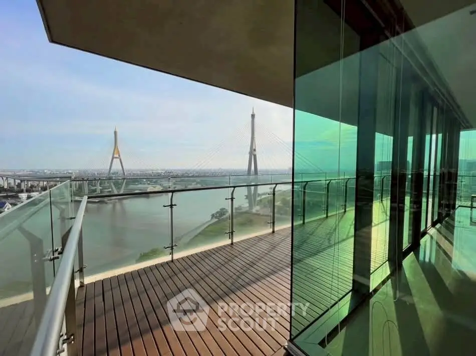 Stunning balcony view with river and bridge, modern glass railing, perfect for relaxation.