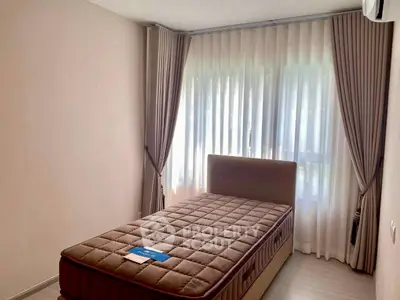 Cozy bedroom with elegant curtains and comfortable bed in modern apartment.