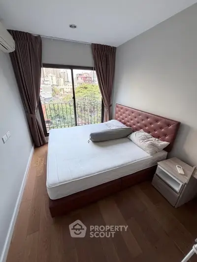 Cozy bedroom with city view, featuring a comfortable bed and elegant decor.