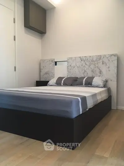 Modern bedroom with stylish marble headboard and sleek wooden flooring