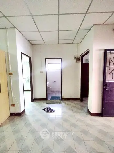 Spacious interior with tiled flooring and multiple doorways, ideal for customization.