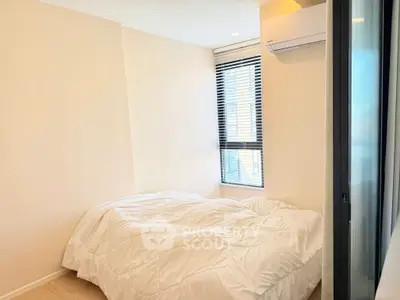 Cozy bedroom with natural light and modern air conditioning unit, perfect for relaxation.