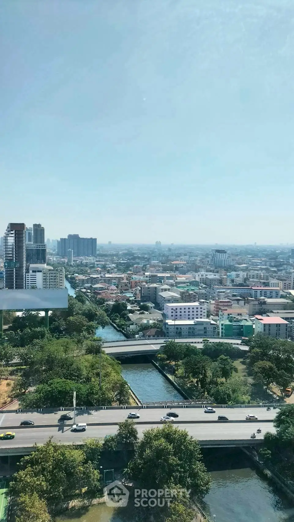 Stunning cityscape view from high-rise building showcasing urban skyline and lush greenery.