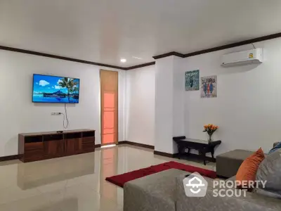 Spacious living room with modern decor and wall-mounted TV