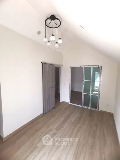 Spacious room with modern sliding doors and elegant lighting fixture