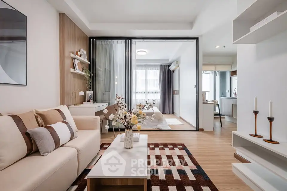 Modern living room with stylish decor and open layout leading to a cozy bedroom.