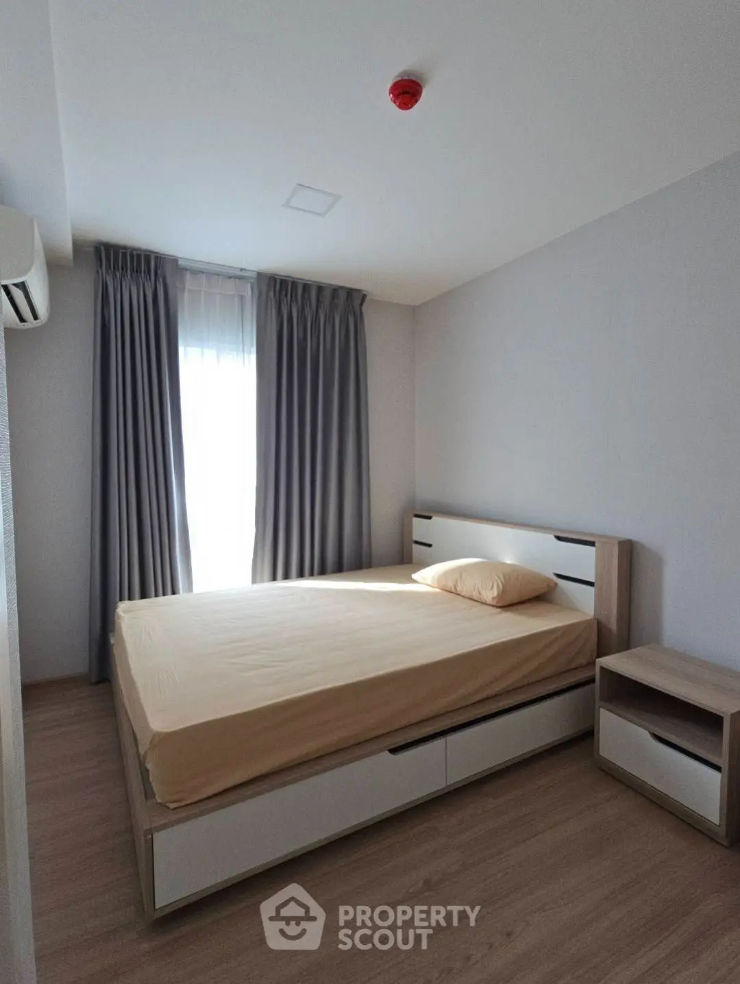 Modern minimalist bedroom with natural light and sleek furnishings.