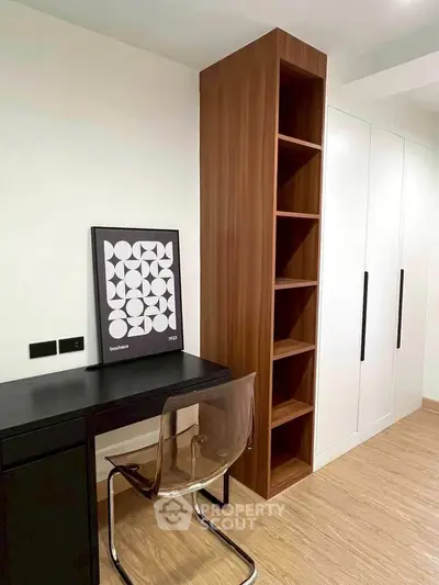 Modern study room with sleek desk, transparent chair, and stylish shelving unit.