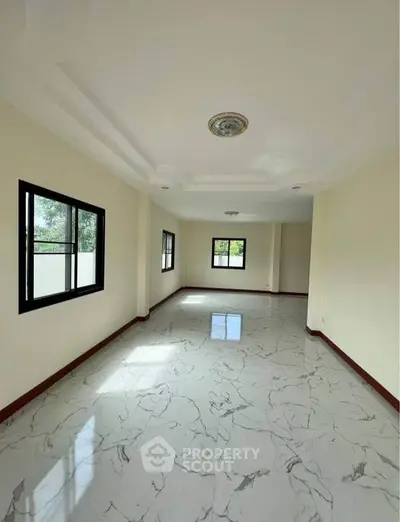 Spacious empty living room with marble flooring and large windows