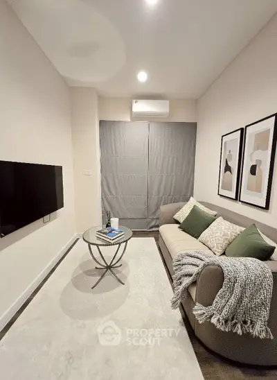 Cozy living room with modern decor and wall art, featuring a comfortable sofa and sleek TV setup.