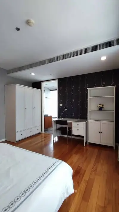 Spacious bedroom with elegant wooden flooring and modern furniture