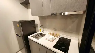 Modern compact kitchen with sleek cabinetry and induction cooktop in a stylish apartment.