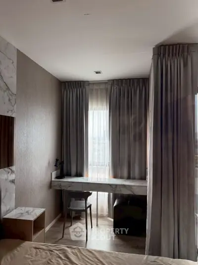 Elegant bedroom with marble desk and floor-to-ceiling curtains, perfect for a cozy workspace.