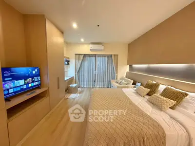 Luxurious modern bedroom with cozy decor and large TV