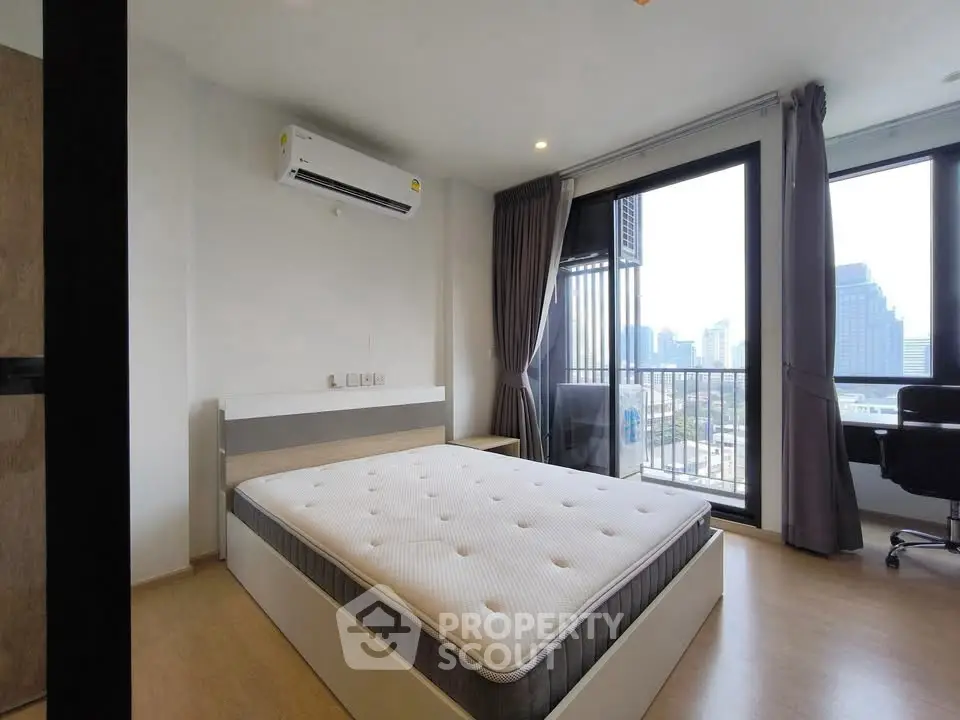 Modern bedroom with city view and balcony access in urban apartment