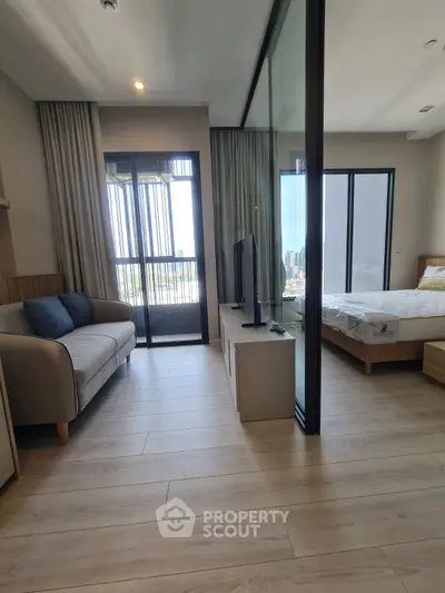 Modern apartment with glass partition, cozy living area, and bright bedroom with balcony view.