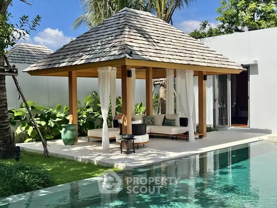 Luxurious tropical villa with poolside gazebo and lush greenery, perfect for relaxation and leisure.