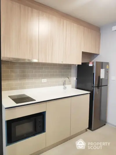 Modern kitchen with sleek cabinetry and stainless steel appliances in a stylish apartment.