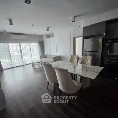 Spacious modern living room with elegant dining area and large windows.