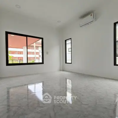 Spacious empty room with glossy marble floors and large windows, perfect for customization.