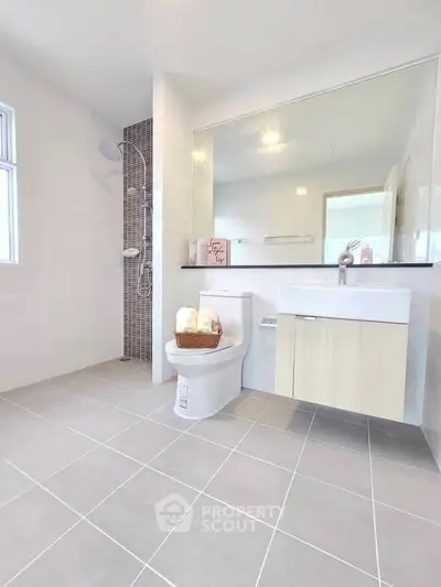 Spacious modern bathroom with sleek fixtures and large mirror