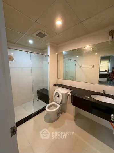 Modern bathroom with glass shower and sleek black countertop