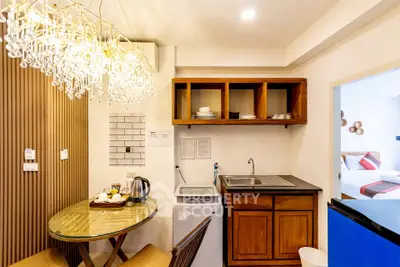 Chic kitchen nook with modern lighting and compact appliances in cozy apartment