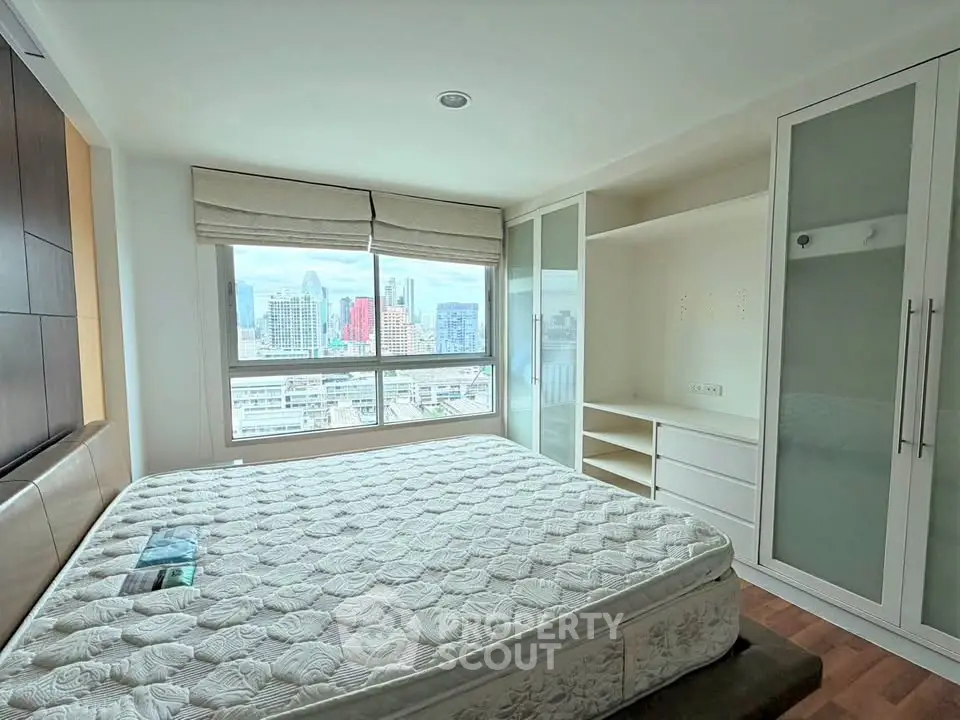 Spacious bedroom with city view and built-in wardrobe in modern apartment