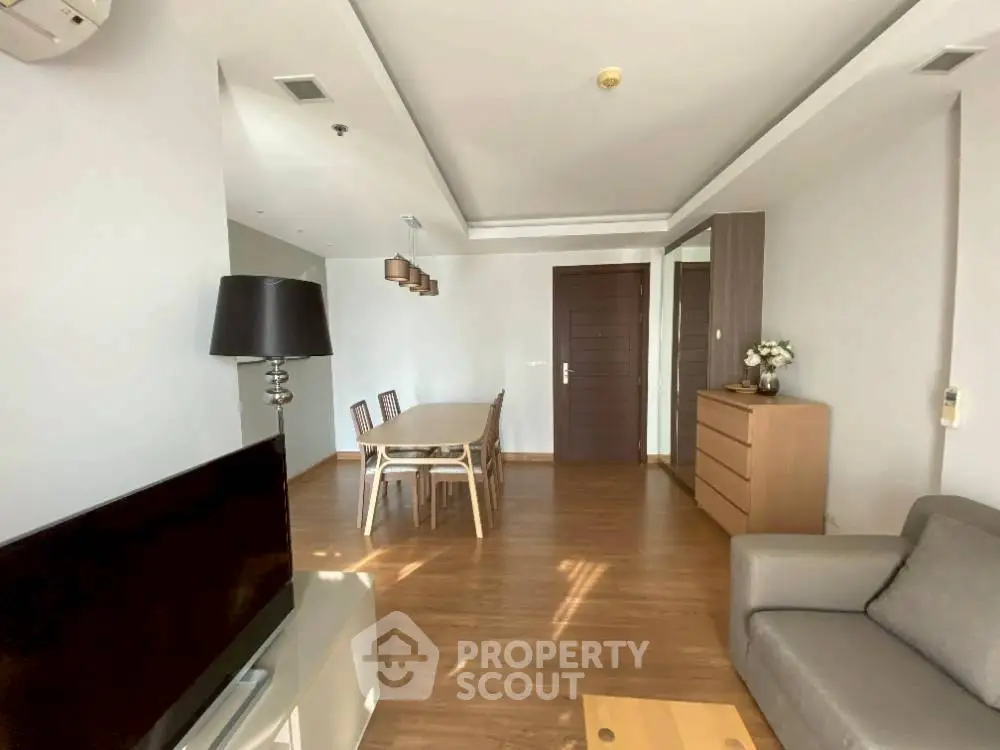 Spacious living room with modern furniture and wooden flooring.