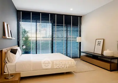 Modern bedroom with large windows and stylish decor in a contemporary apartment.