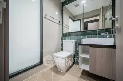 Modern bathroom with sleek design, featuring a glass shower, stylish sink, and elegant tile work.