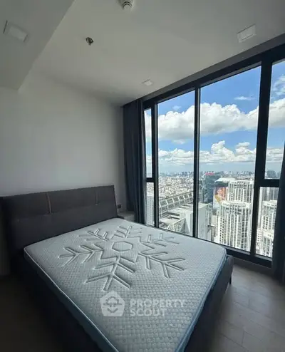 Modern bedroom with stunning city view from floor-to-ceiling windows.