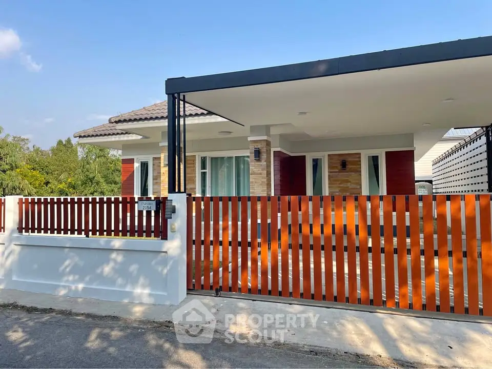 Charming single-story house with modern fence and spacious driveway, perfect for family living.