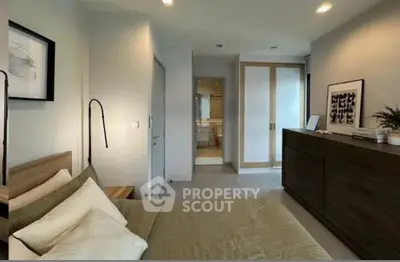 Modern bedroom with elegant decor and ensuite bathroom in a stylish apartment.