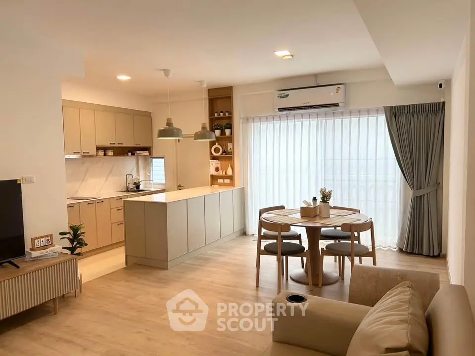 Modern open-plan living room and kitchen with stylish decor and natural light.