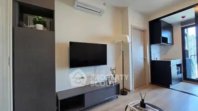 Modern living room with sleek TV setup and open kitchen layout