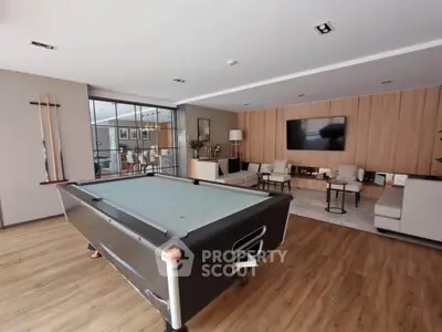 Spacious living room with pool table and modern decor, perfect for entertainment and relaxation.