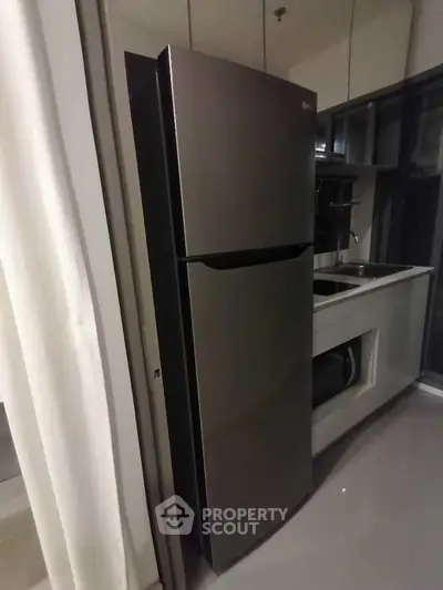 Modern kitchen with sleek stainless steel refrigerator and minimalist design.