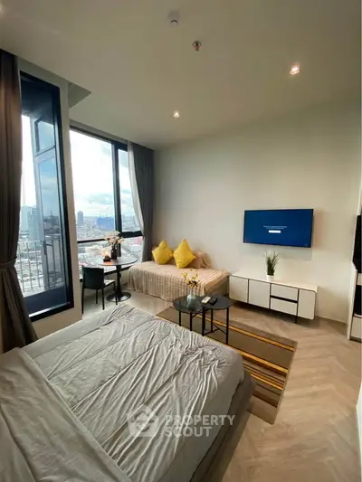 Modern living room with city view, featuring cozy seating and stylish decor.