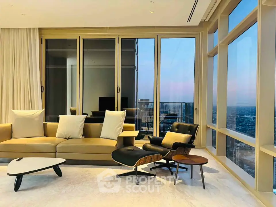 Luxurious living room with panoramic city views and modern furniture in high-rise apartment.