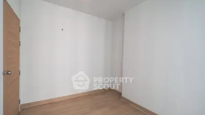 Minimalist empty room with wooden flooring and white walls, ready for customization.