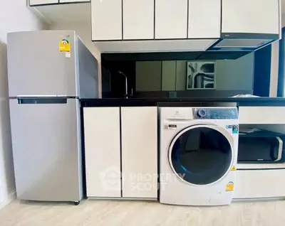 Modern kitchen with sleek appliances including fridge and washing machine, stylish cabinetry, and contemporary design.