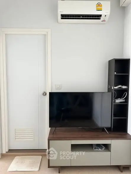 Modern living room with sleek TV stand and air conditioning unit, perfect for cozy relaxation.