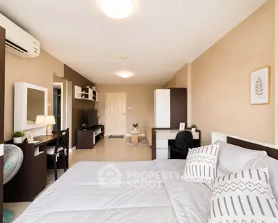 Spacious bedroom with modern decor and ample natural light, featuring a cozy workspace and stylish furnishings.