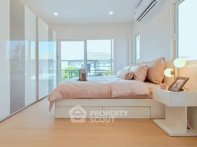 Bright and modern bedroom with large windows and stylish decor, perfect for a cozy retreat.