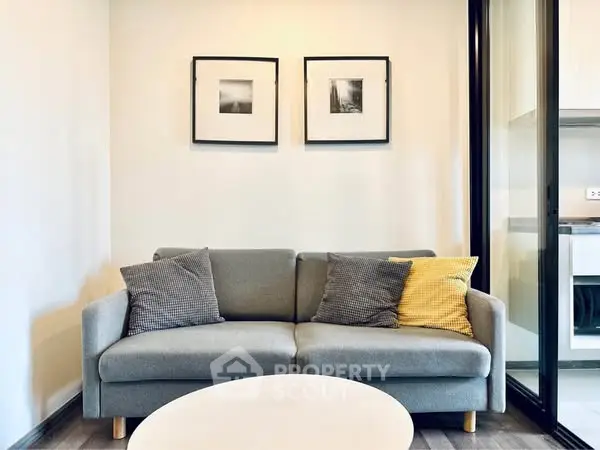 Modern living room with stylish gray sofa and framed art on wall