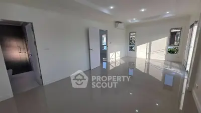 Spacious modern living room with glossy tiled floors and natural light