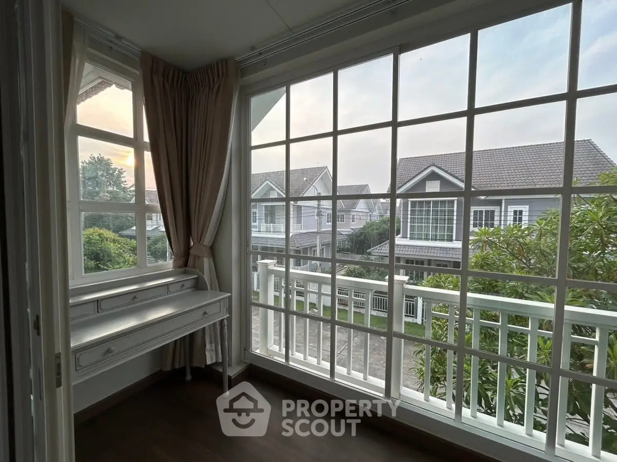 Charming corner unit with large windows offering a picturesque view of suburban homes and lush greenery.