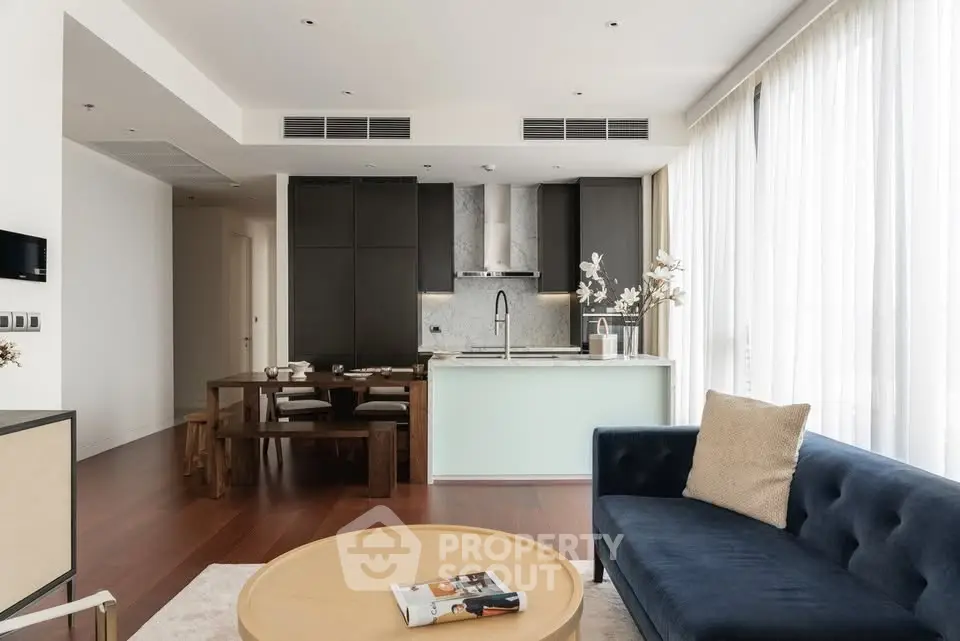 Modern open-plan living room with sleek kitchen and elegant furnishings.